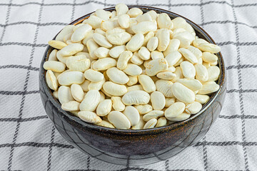 a bowl full of white beans on a kitchen towel