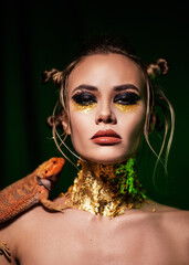 Close-up beauty portrait of a girl with a dragon-lizard on her shoulder