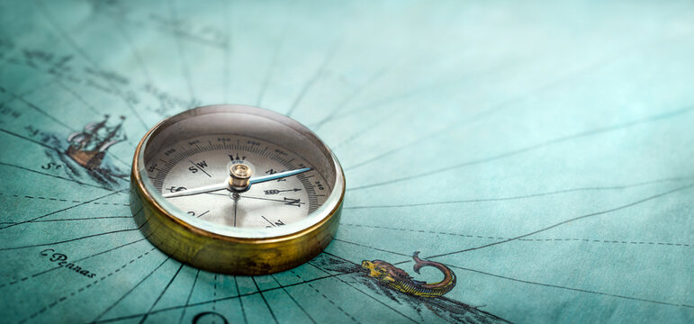 Magnetic old compass on world map. Travel, geography, history, navigation, tourism and exploration concept background. Retro compass on geography map.