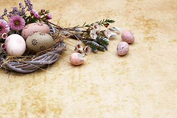 Fototapeta na wymiar Decorative Easter basket with Easter eggs, flowers and space for text.