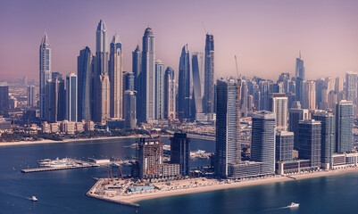 Fototapeta premium Aerial top view futuristic skyscraper of Dubai, panorama Marina JBR sand beaches, sunset. Concept Modern building in UAE