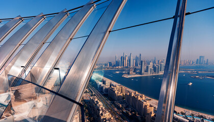 Observation deck skyview on sandy artificial Palm Island in Dubai and modern skyscraper. Famous tourist landmark of city UAE