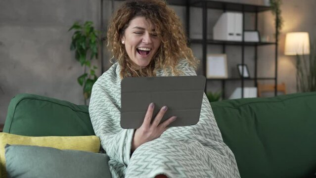 Woman sit at home use digital tablet to watch movie or have video call