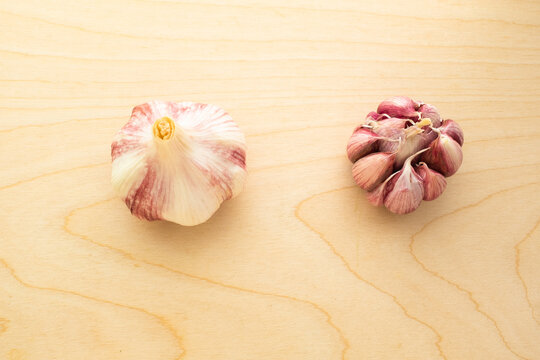 Two garlic heads on the wooden table background for publication, poster, screensaver, wallpaper, postcard, banner, cover, post. High quality photo