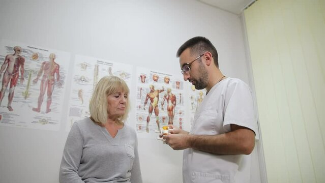 An orthopedist conducts a medical examination of an elderly patient in the clinic. Traumatology.