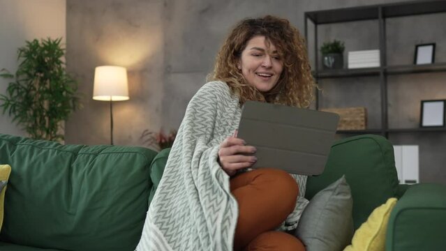 Woman sit at home use digital tablet to watch movie or have video call