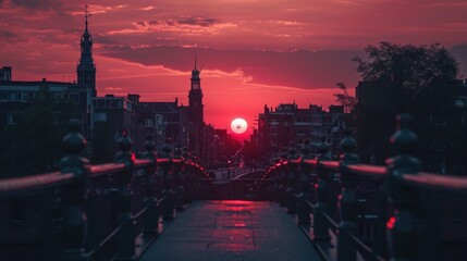  the sun is setting over a city with a bridge in the foreground and tall buildings on the other side of the bridge, with a red sky in the background.