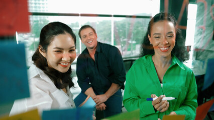 Portrait of professional diverse business team brainstorming marketing idea on colorful sticky...