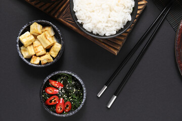 Composition with different Chinese dishes on dark background, closeup