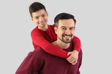 Obraz premium Portrait of father and his little son on light background