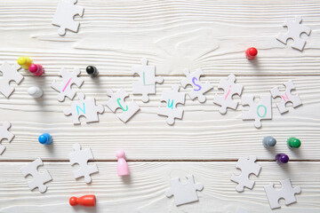 Puzzle pieces with word INCLUSION and pawns on white wooden background