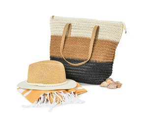 Stylish beach bag, hat and towel on white background
