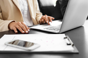 Businesswoman working with laptop at table in conference hall, closeup