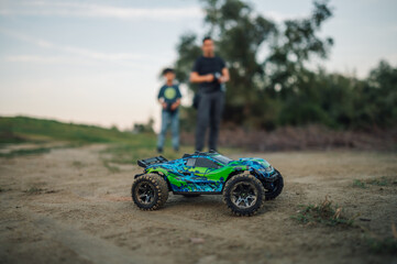 Fototapeta na wymiar Selective focus on a monster car with father and son in a blurry background.