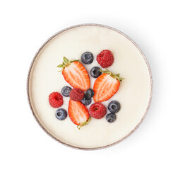 Bowl of tasty semolina porridge with fresh berries on white background