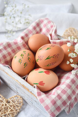 Easter eggs on a rustic table in a wooden box on a napkin.