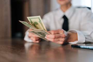 Closeup female hands of counting American currency. Closeup cropped shot of business woman counting...