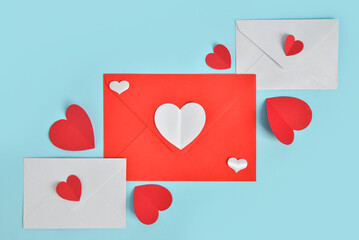 Envelopes with paper hearts on blue background