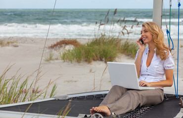 Young Woman Remote Working On Line Using Laptop On Boat At Beach