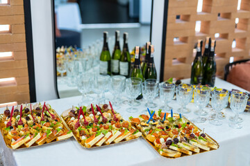 Buffet table with snacks and wine glasses at party