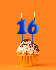 Blue candle number 16 - Birthday cupcake on orange background