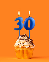 Blue candle number 30 - Birthday cupcake on orange background
