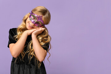 Happy little girl wearing carnival mask on lilac background