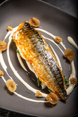 Pescado fresco con salsa con hierbas decorativas servido en un plato y decorado en una mesa de restaurante delicioso y muy jugoso