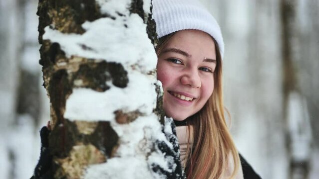 Portrait of a girl in winter in a birch forest.