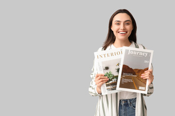 Young woman with magazines on light background