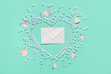Composition with envelope and heart-shaped glass stones on color background. Valentine's Day...