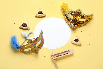 Blank card with carnival masks, Hamantaschen cookies and rattle for Purim holiday on yellow...