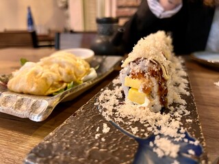 closeup of japanese food in a restaurant. mango nigiri with grated cheese