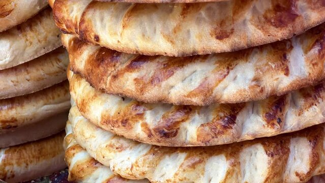 Tortillas on the market in Samarkand, Uzbekistan - June 29, 2023: Goods and traders at the Oriental Bazaar in Uzbekistan. Siab Bazaar is the largest and oldest bazaar in Samarkand. 4K