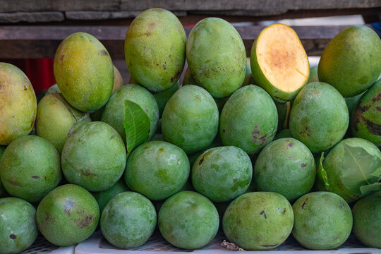 Display of Mangga Manalagi (Manalagi Mango variety) or Honey mango on a market stall. Known for its green skin and yellow with orange spot at the center of its flesh. Very sweet mango.