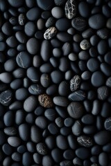 Fototapeta na wymiar vertical dark pebbles texture background, closeup black smooth stones