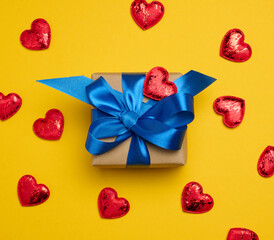 Box tied with a blue ribbon and small hearts on a yellow background
