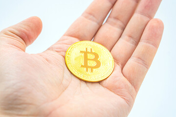Holding Bitcoin: The Future of Money in the Palm of Hand. Open palm handful of bitcoins as a...