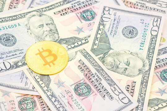 Bitcoin on top of United States Dollar Banknotes. Bitcoin cash BTC, cryptocurrency pictured as a gold, gold coin lying over dollars, real US money, 50 dollars, United States fifty-dollar bill