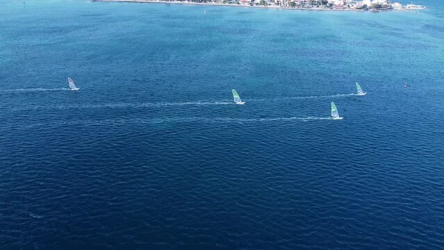 Windsurfers at the winter, aerial training footage 4k. This video made with a drone at sunset with a windsurfers on the board surfing at winter period in Loutsa, Greece