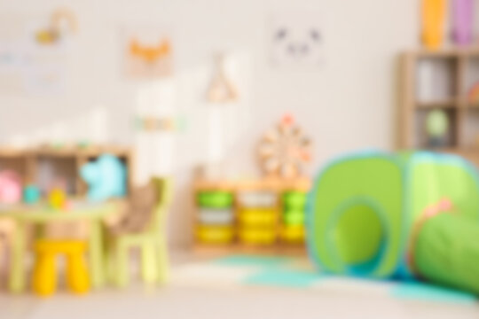 Blurred view of playroom with toys and pictures in kindergarten