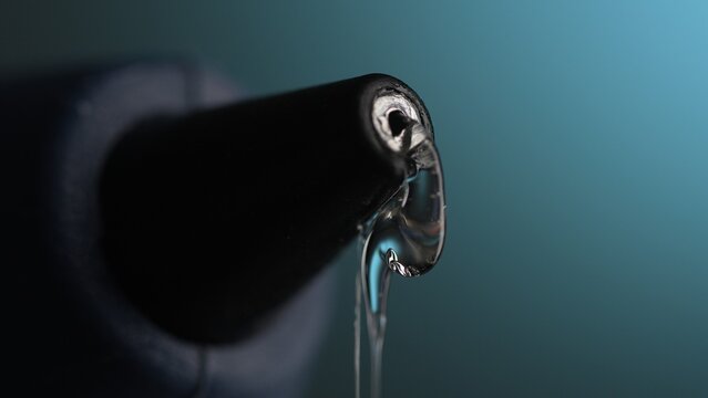 Glue gun Nozzle with Hot Liquid Glue. Close-up, shallow dof.