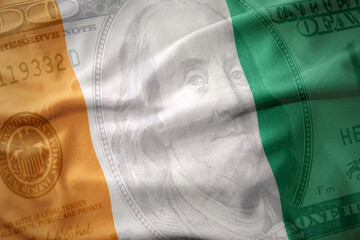 waving colorful flag of cote d'ivoire on a american dollar money background. finance concept.