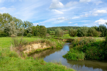 Summer landscape of hilly countryside of South Limburg (Zuid-Limburg) Small kleine Geul river in between the farm, Epen is a village in the southern part of the Dutch province of Limburg, Netherlands.