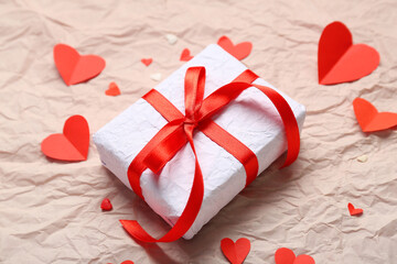 Gift box and hearts on crumpled paper. Valentine's Day celebration