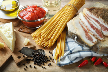 Ingredients for Amatriciana pasta. Bucatini, pancetta, peeled tomatoes, pecorino cheese, extra virgin olive oil, white wine, chilli and salt.