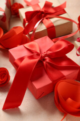 Gift box and red paper roses on beige background. Valentine's Day celebration