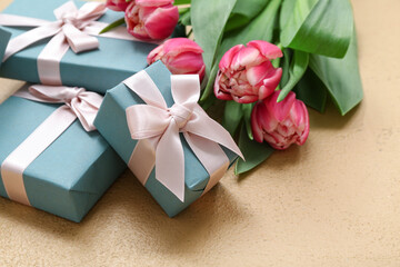 Gift boxes and beautiful tulips on brown background. International Women's Day