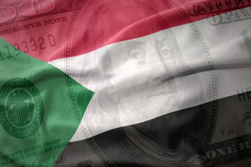 waving colorful flag of sudan on a american dollar money background. finance concept.