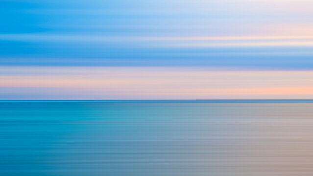 Abstract background of blue sea wave Motion blur sea water and beautiful sunset with clouds